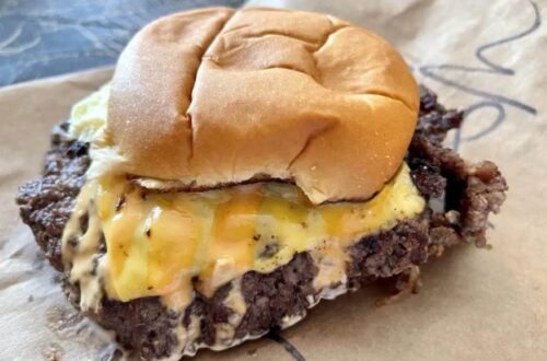Crispy smash burger stacked high with cheese and onions at Ted’s Burgers in Wynwood, Miami.