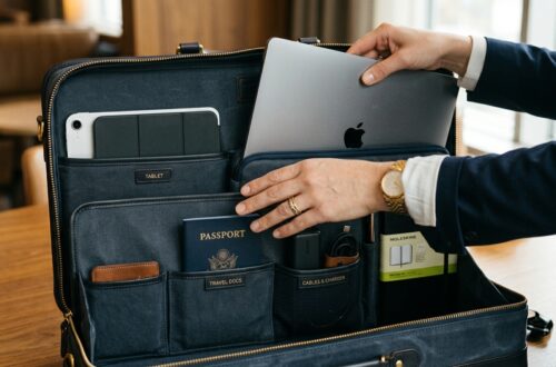 Professional laptop backpack resting on a carry-on suitcase at an airport